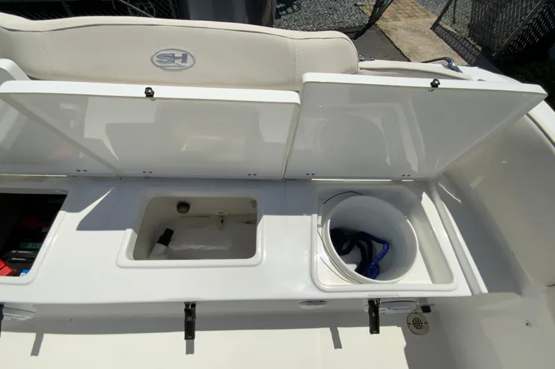 Slide: The Image of 2024 Sea Hunt Ultra 234 boat storage compartments with open lids and visible equipment. - 31