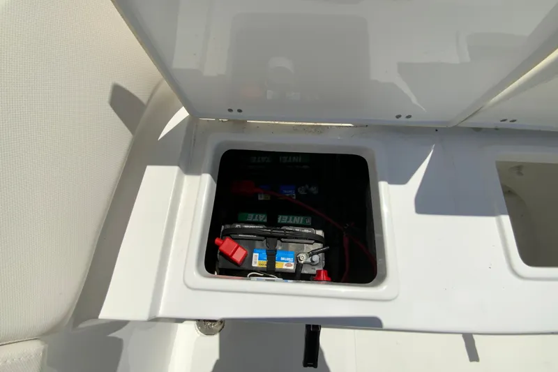 Slide: The Image of 2024 Sea Hunt Ultra 234 boat battery compartment with visible wiring and connections. - 32