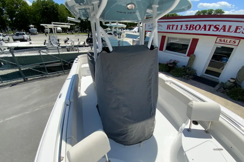Slide: The Image of 2024 Sea Hunt Ultra 234 boat displayed at dealership, featuring covered console and seating. - 36
