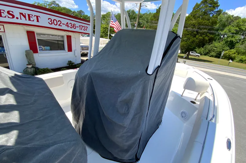 Slide: The Image of 2024 Sea Hunt Ultra 234 boat with covered console, parked near a sales office. - 38