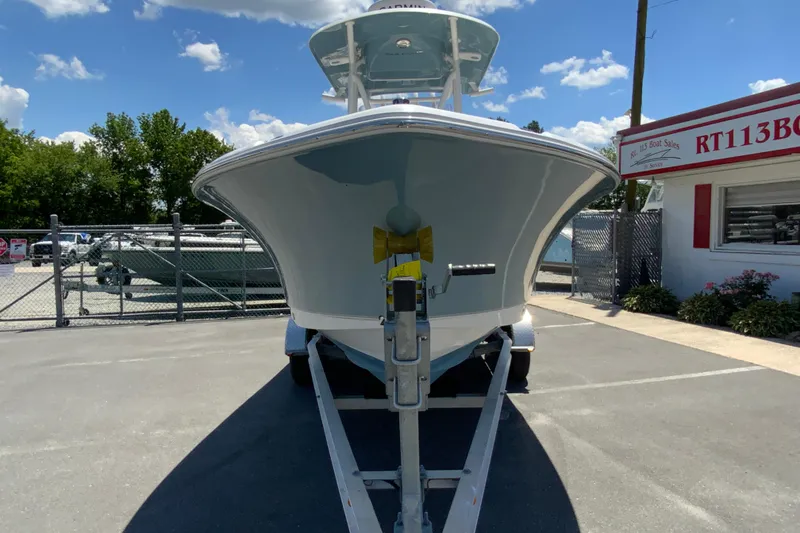 Slide: The Image of 2024 Sea Hunt Ultra 234 boat on trailer at dealership under blue sky. - 4