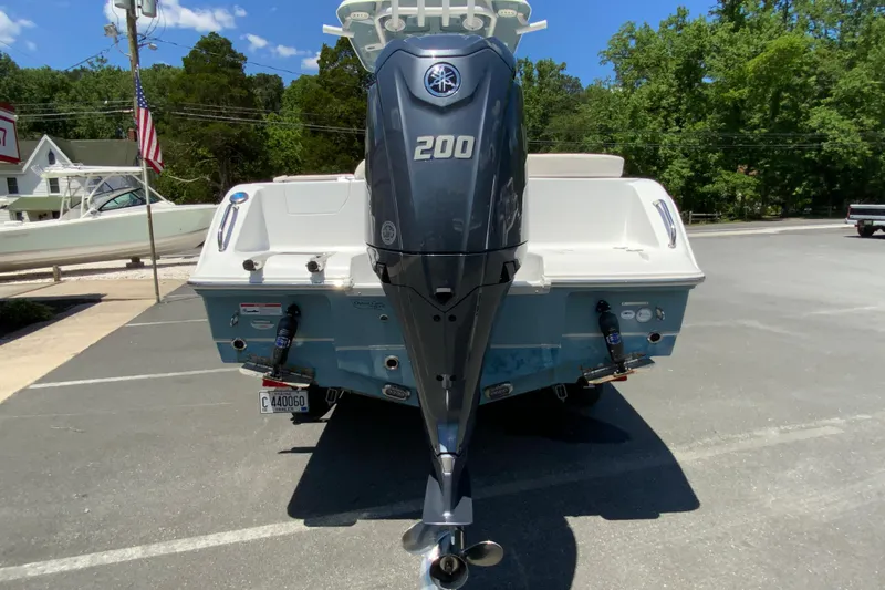 Slide: The Image of 2024 Sea Hunt Ultra 234 boat with powerful 200 horsepower engine, parked outdoors. - 9