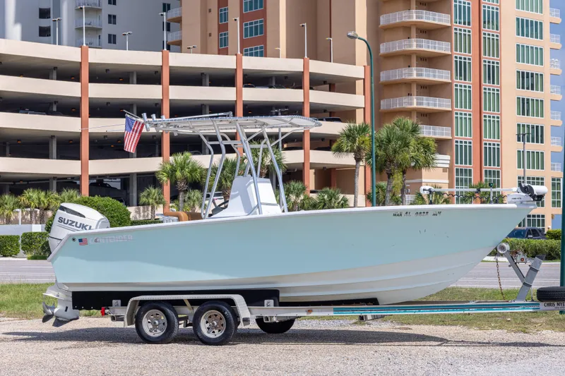 The Image of 1998 Contender 21 CC boat on trailer, parked near modern buildings. - 0
