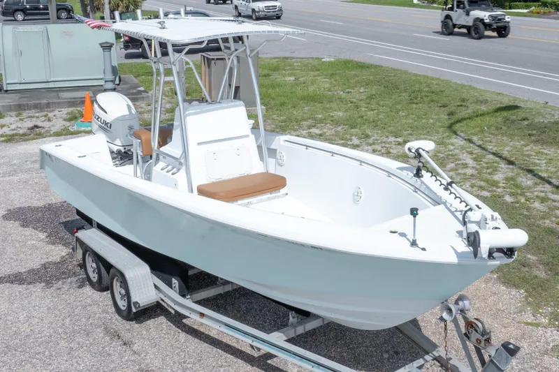 Slide: The Image of 1998 Contender 21 CC boat on trailer, featuring Suzuki outboard motor. - 1