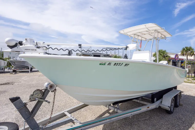 Slide: The Image of 1998 Contender 21 CC boat on trailer, featuring Minn Kota trolling motor, under clear sky. - 12
