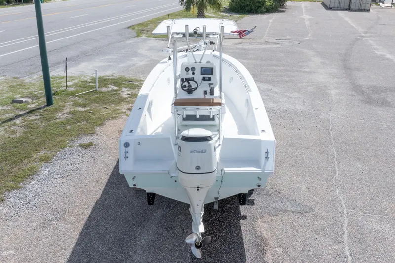 Slide: The Image of 1998 Contender 21 CC boat with outboard motor, parked on a paved area. - 19