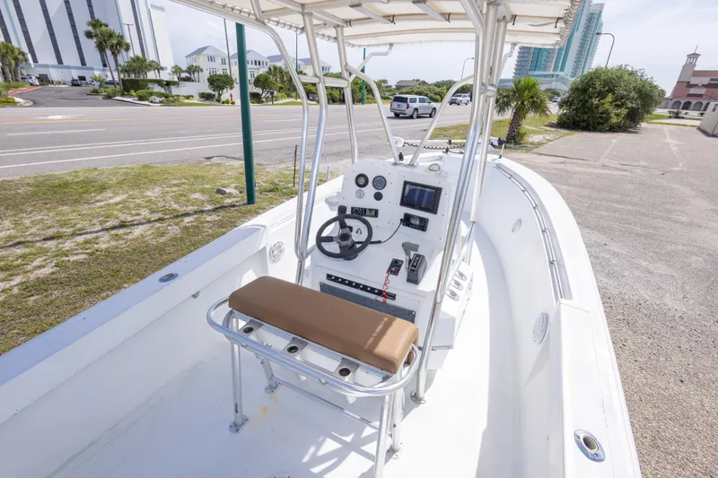 Slide: The Image of 1998 Contender 21 CC boat interior with steering console and seating, parked near a road. - 22