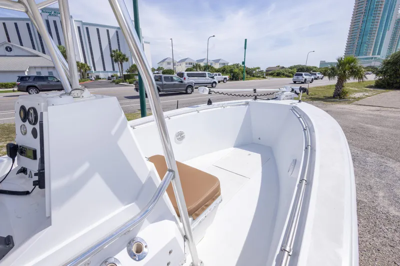 Slide: The Image of 1998 Contender 21 CC boat parked near a road with modern buildings in the background. - 28