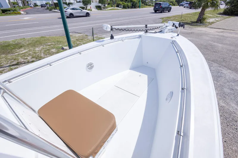 Slide: The Image of 1998 Contender 21 CC boat with open deck and seating, parked near a road. - 31