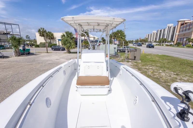 Slide: The Image of 1998 Contender 21 CC boat with T-top, parked near a road and buildings. - 32