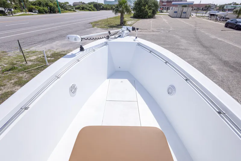 Slide: The Image of 1998 Contender 21 CC boat bow with seating, parked near a road. - 33