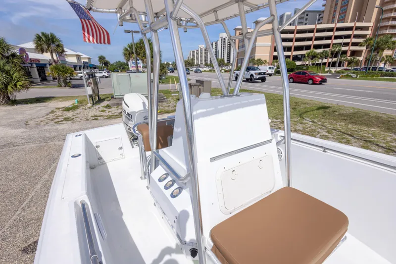 Slide: The Image of 1998 Contender 21 CC boat with Suzuki engine, parked near a road with American flag. - 34