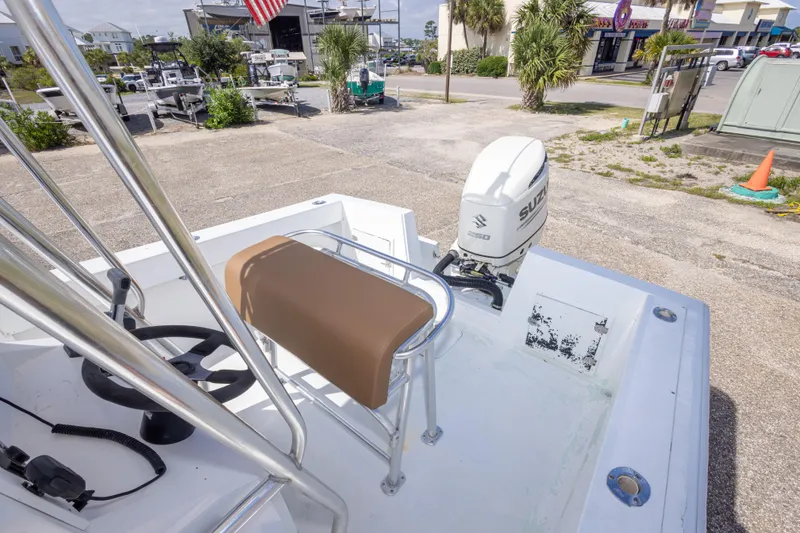 Slide: The Image of 1998 Contender 21 CC boat with Suzuki outboard motor, parked outdoors. - 36