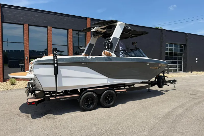 Slide: The Image of 2022 Nautique Super Air Nautique G23 boat on trailer, parked outside a modern building. - 3