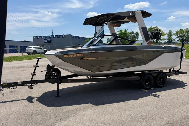 Slide: The Image of 2022 Nautique Super Air Nautique G23 boat on trailer, parked outdoors under a clear sky. - 7