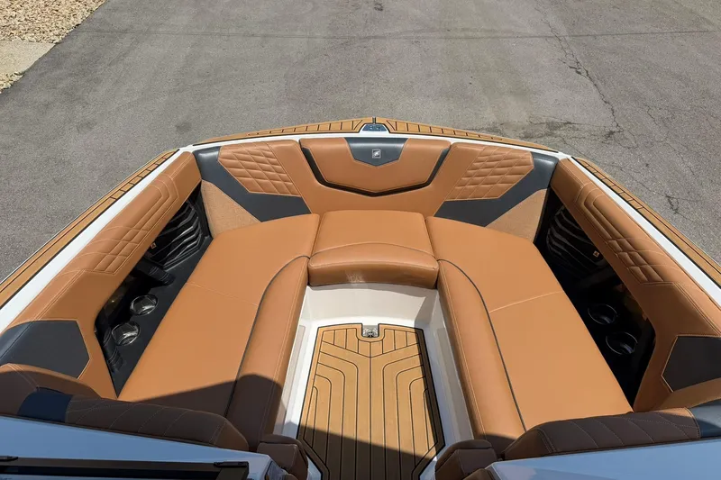 Slide: The Image of 2022 Nautique Super Air Nautique G23 boat interior with tan leather seating and cup holders. - 9