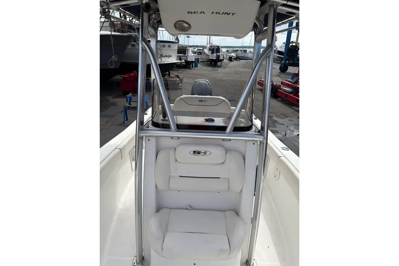 Slide: The Image of 2015 Sea Hunt Ultra 196 boat interior with seating and console, docked at marina. - 8