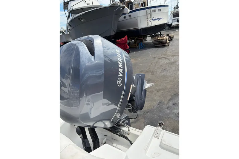 Slide: The Image of 2015 Sea Hunt Ultra 196 with Yamaha outboard motor in a boatyard setting. - 9