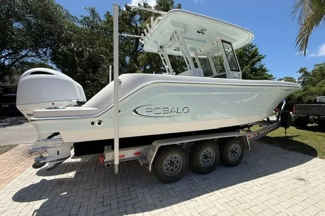 The Image of 2019 Robalo R272 Center Console boat on a trailer, parked outdoors. - 1