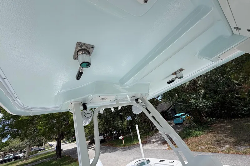 Slide: The Image of 2019 Robalo R272 Center Console boat's T-top and electronics, parked outdoors. - 11