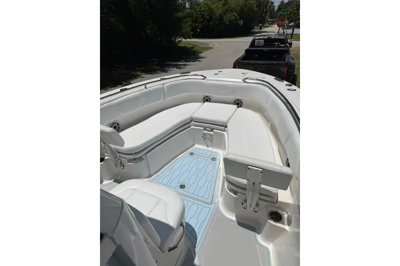 Slide: The Image of 2019 Robalo R272 Center Console boat interior with white seating and blue flooring. - 9