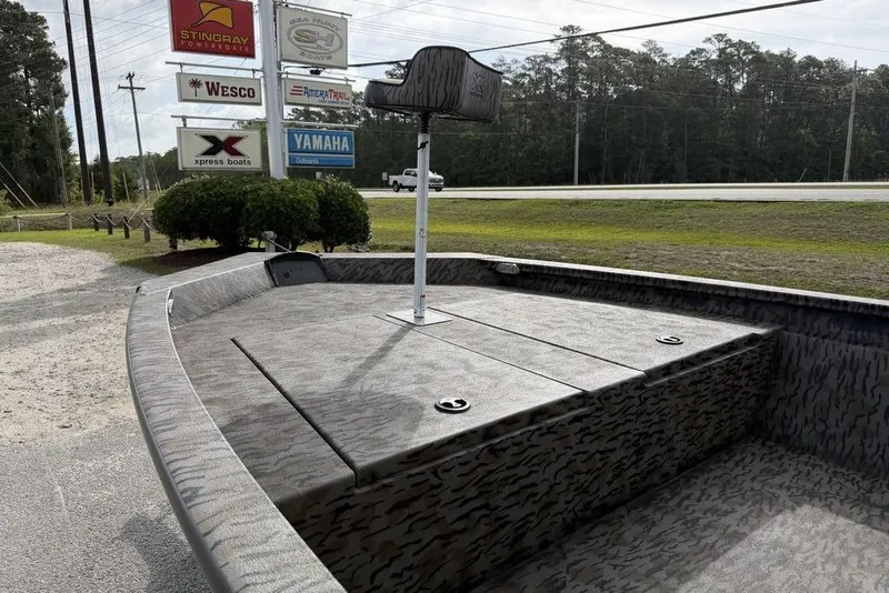 Slide: The Image of 2026 Xpress H190B Bay boat with camouflage design, parked near dealership signs. - 12