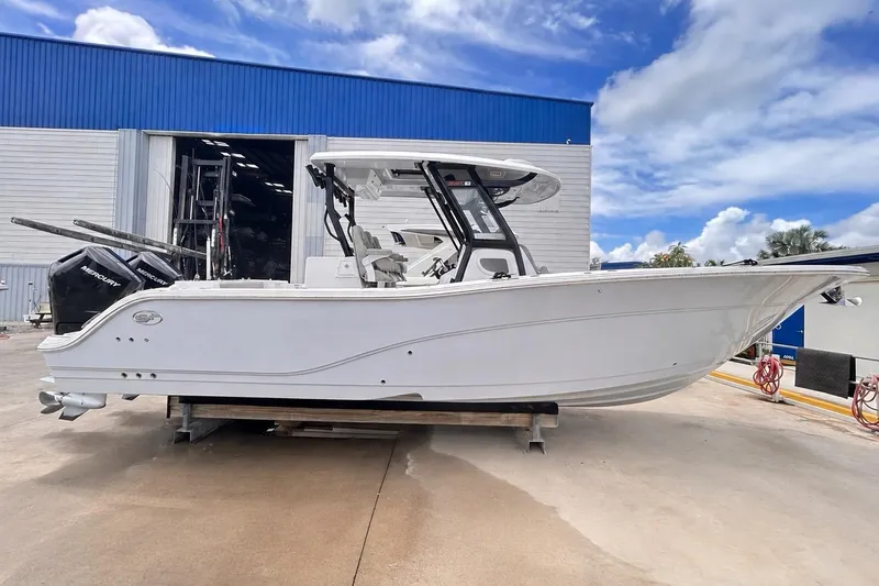 The Image of 2024 Sea Fox 328 Commander boat on display outside a blue warehouse. - 0