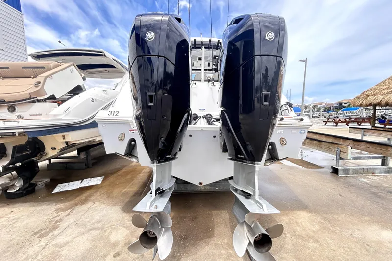 Slide: The Image of 2024 Sea Fox 328 Commander with dual outboard engines at a marina. - 2
