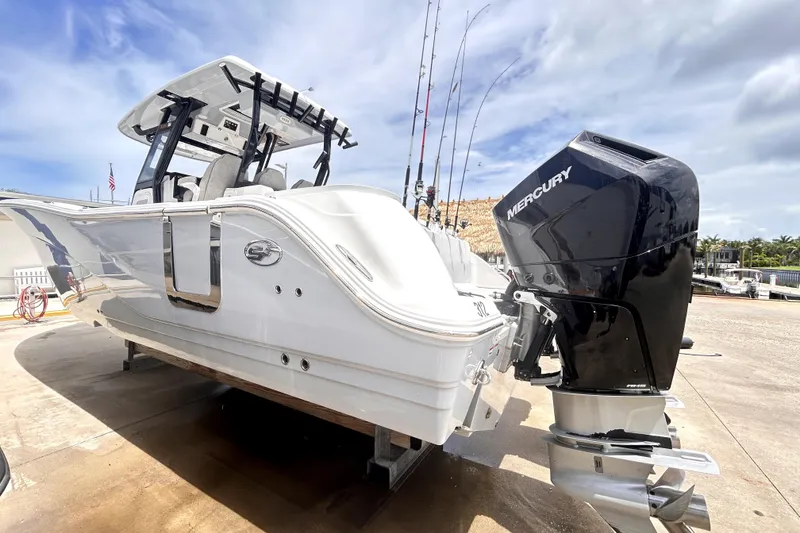 Slide: The Image of 2024 Sea Fox 328 Commander boat with Mercury outboard engine, docked under a cloudy sky. - 5