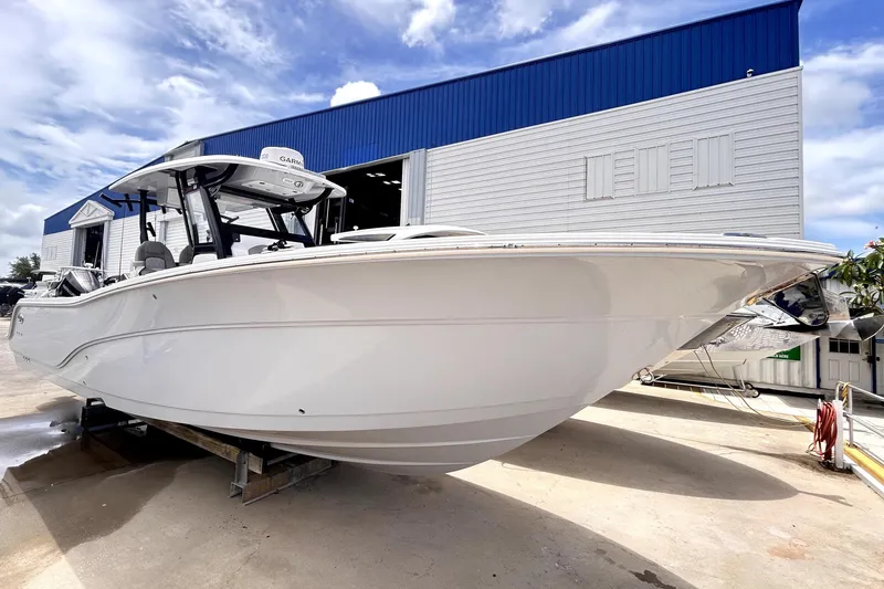 Slide: The Image of 2024 Sea Fox 328 Commander boat displayed outdoors near a blue and white building. - 9