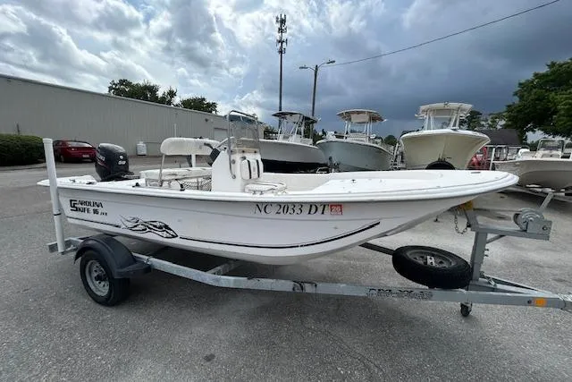 Slide: The Image of 2011 Carolina Skiff JVX16CC boat on trailer, parked outdoors under cloudy sky. - 3