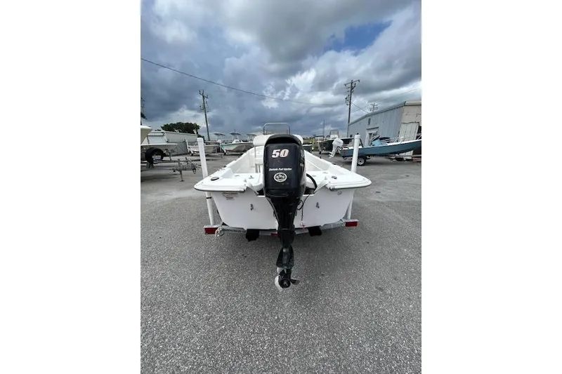 Slide: The Image of 2011 Carolina Skiff JVX16CC boat with 50 HP motor, parked outdoors under cloudy skies. - 8
