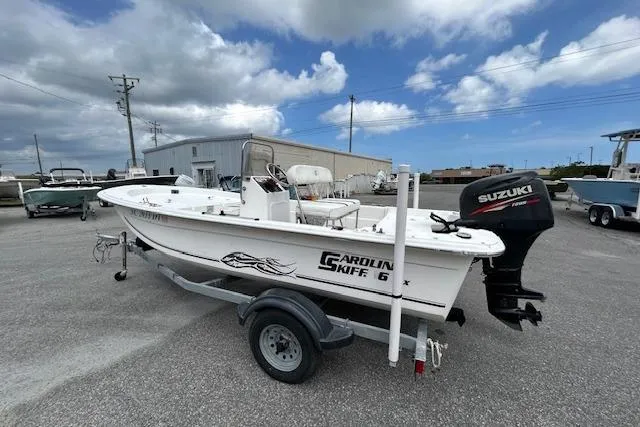 Slide: The Image of 2011 Carolina Skiff JVX16CC boat with Suzuki outboard motor on trailer, parked outdoors. - 9