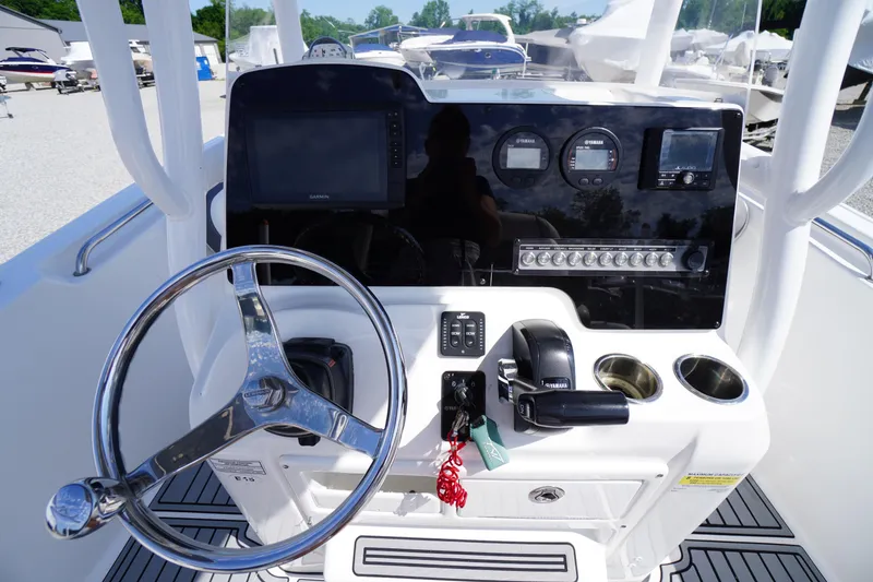 Slide: The Image of 2020 Tidewater 220 LXF boat dashboard with steering wheel and control panel. - 13