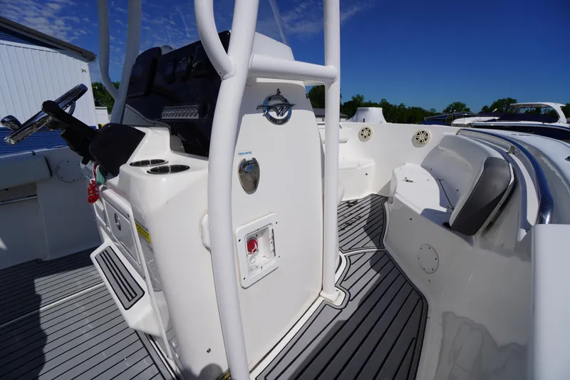 Slide: The Image of 2020 Tidewater 220 LXF boat interior with steering console and seating, under clear blue sky. - 18