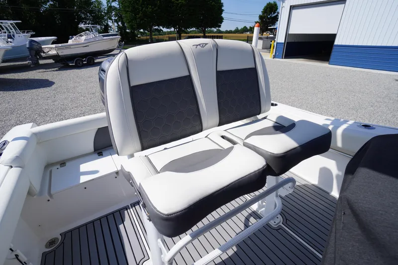 Slide: The Image of 2020 Tidewater 220 LXF boat seating with gray and white upholstery in a sunny outdoor setting. - 20