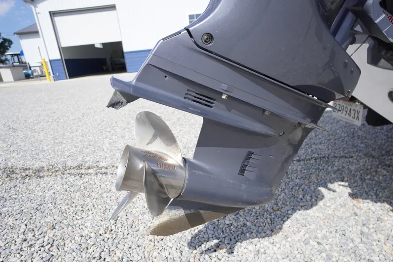Slide: The Image of 2020 Tidewater 220 LXF boat propeller on gravel near a building. - 40