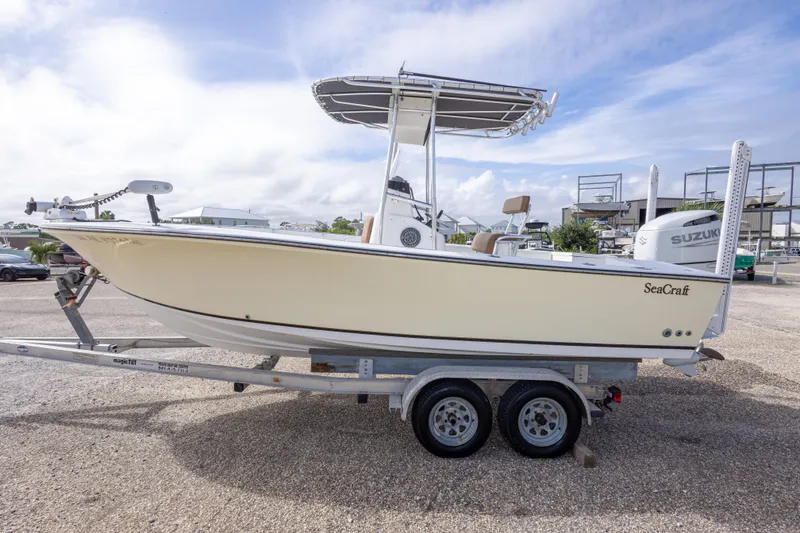 Slide: The Image of 2004 Sea Craft 23 CC boat on trailer, side view, outdoors under cloudy sky. - 10