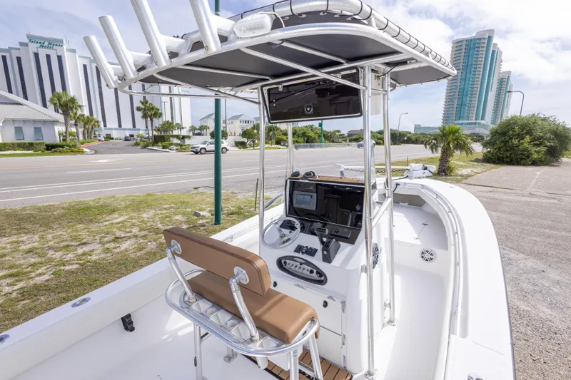 Slide: The Image of 2004 Sea Craft 23 CC boat with console, parked near coastal road and modern buildings. - 18