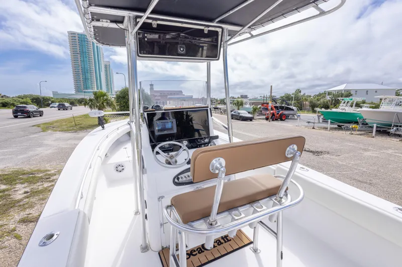 Slide: The Image of 2004 Sea Craft 23 CC boat with console and seating, parked near a coastal road. - 19