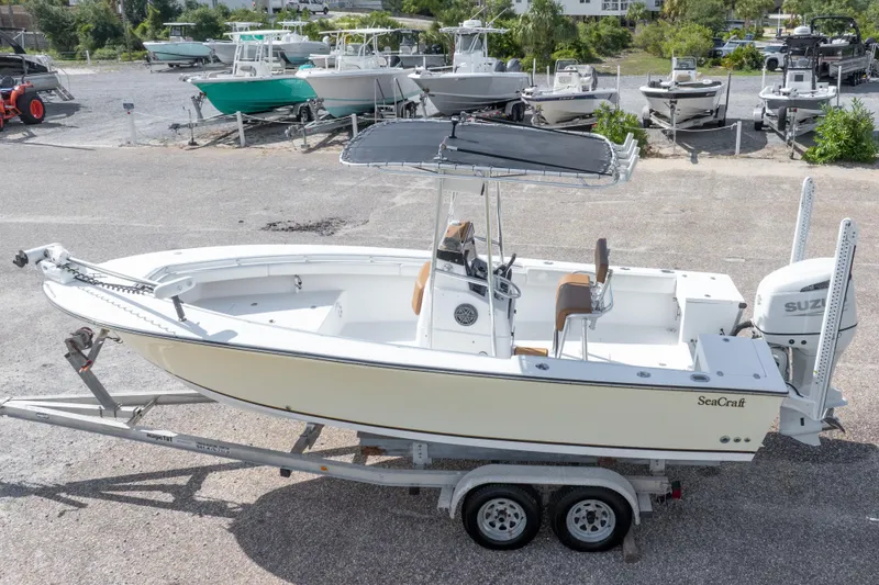 Slide: The Image of 2004 Sea Craft 23 CC boat on trailer, parked in a marina with other boats. - 3