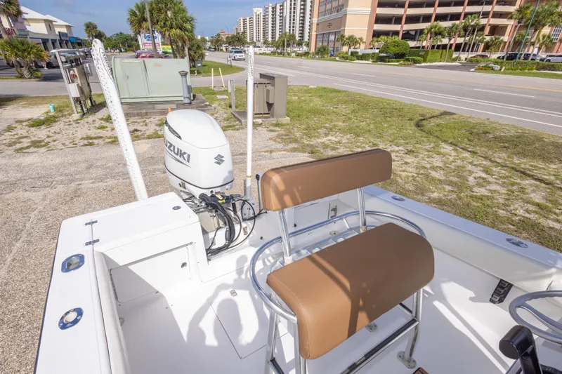 Slide: The Image of 2004 Sea Craft 23 CC boat with Suzuki outboard motor, parked near a road. - 34
