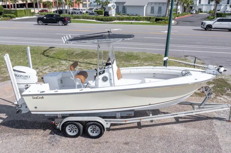 Slide: The Image of 2004 Sea Craft 23 CC boat on trailer with Suzuki engine, parked roadside. - 38
