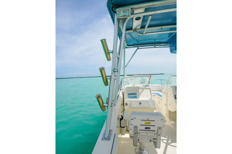 Slide: The Image of 2006 World Cat 250 DC boat interior with rod holders, turquoise water, and blue sky. - 12