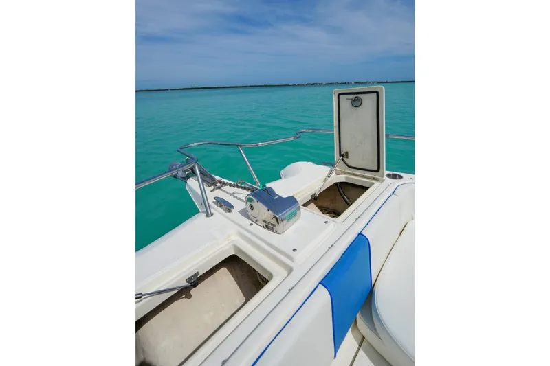 Slide: The Image of 2006 World Cat 250 DC boat deck with open storage, turquoise water background. - 18