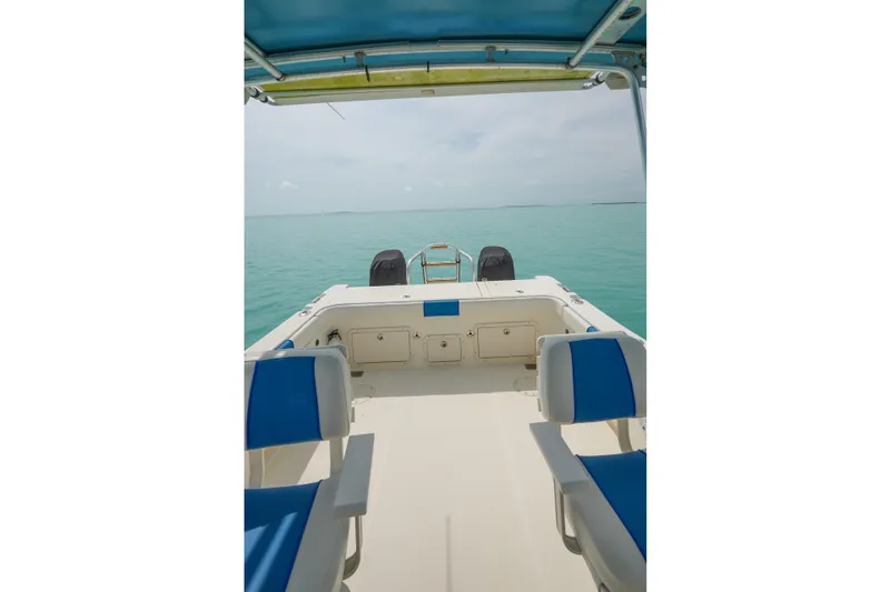 Slide: The Image of 2006 World Cat 250 DC boat interior with blue seating, overlooking calm turquoise waters. - 20