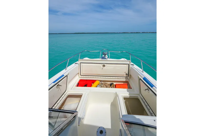 Slide: The Image of 2006 World Cat 250 DC boat with open storage compartments on turquoise water. - 21