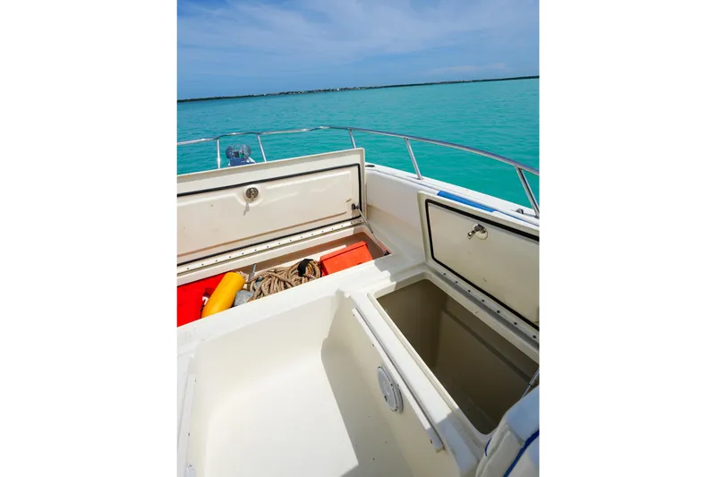Slide: The Image of Open storage compartments on a 2006 World Cat 250 DC boat, with turquoise water background. - 22
