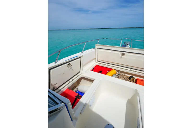 Slide: The Image of 2006 World Cat 250 DC boat storage compartments with safety gear on turquoise water. - 23