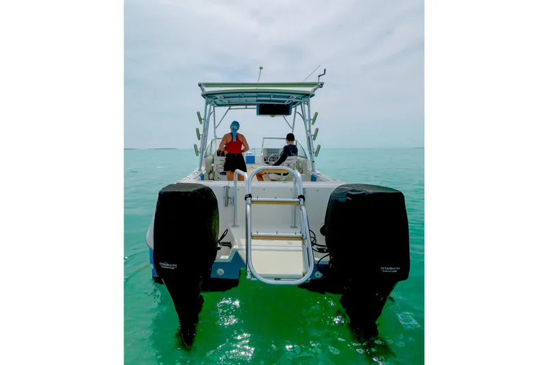 Slide: The Image of 2006 World Cat 250 DC boat on clear turquoise water, rear view with two people onboard. - 4